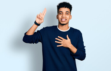 Young african american man wearing casual clothes smiling swearing with hand on chest and fingers...