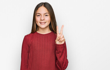 Beautiful brunette little girl wearing casual sweater showing and pointing up with fingers number two while smiling confident and happy.