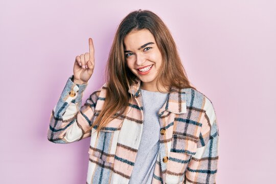 Young caucasian girl wearing casual clothes pointing finger up with successful idea. exited and happy. number one.