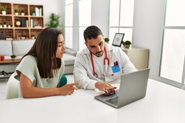 Obraz premium Doctor explain treatment to latin woman using laptop at clinic.