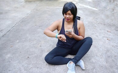 Portrait of Asia woman happy smile fitness sport and using smart phone on hand