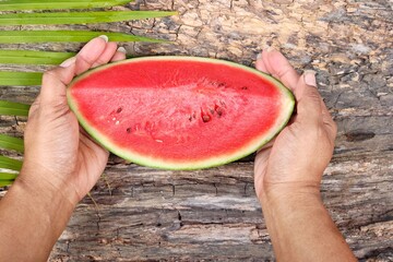 Watermelon summer fruit and hand woman on wood background