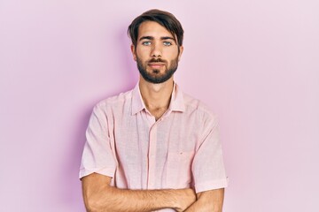 Young hispanic man wearing casual clothes with serious expression on face. simple and natural looking at the camera.