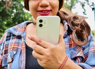 Portrait of Asia woman using smart phone on hand and tropical leaves