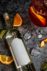Bottle of vodka, white wine, pisco on black background. Pink drink in wine glass on black marble....