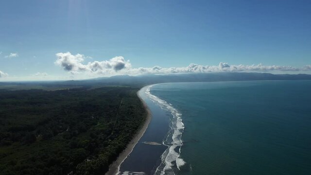Unreal aerial view over Zancudo beach Costa Rica mirror sandy beach jungle along seaside
