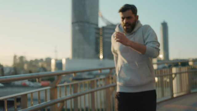 Sporty man using smart watch while resting after run