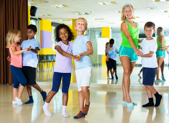 Positive little boys and girls dancing pair dance in the ballet studio. High quality photo