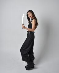 Full length portrait of pretty young asian girl wearing black tank top, utilitarian  pants and...