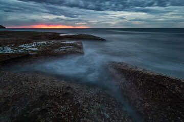 pink glow in the sky during blue hour at the beach