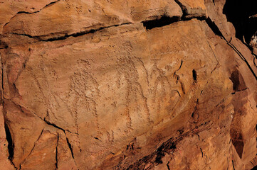 Ancient cave paintings of people carved in stone.
