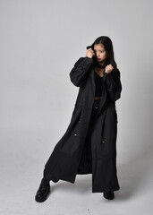 Full length portrait of pretty young asian girl wearing black tank top, utilitarian  pants, leather...