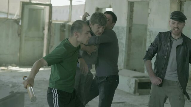 4k Group of men fighting in abandoned building . Friends helping each other during the fight . Drug deal between criminal gangs goes wrong & a fight breaks out .  Staged, scenic shot with artists
