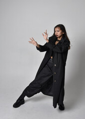Full length portrait of pretty young asian girl wearing black tank top, utilitarian  pants, leather...