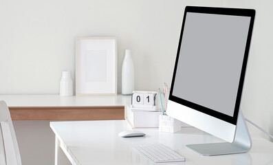 Mockup blank screen monitor on white table.