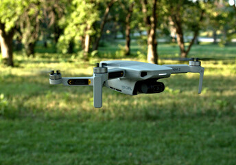 Late Afternoon sunlight shadows in the background of a quad copter in a grassy area