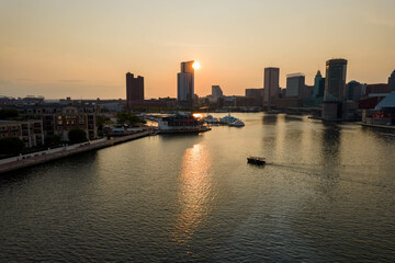 Aerial View of Baltimore City Inner Harbor at Sunset with Boat Passing in the Water