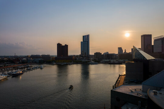 Aerial View of Baltimore City Inner Harbor at Sunset with Boat Passing in the Water