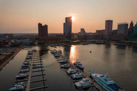 Aerial View of Baltimore City Inner Harbor at Sunset with Boat Passing in the Water
