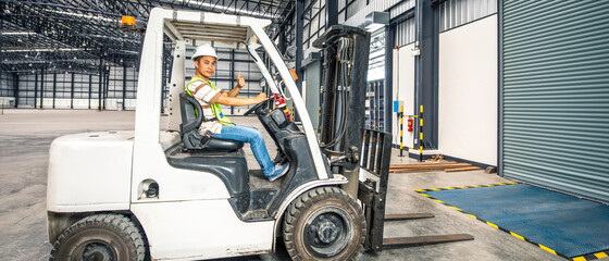 Banner photo of worker driving a forklift in a warehouse in logistic area