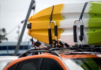 Kayak on the roof of an orange car parked near Westport docks