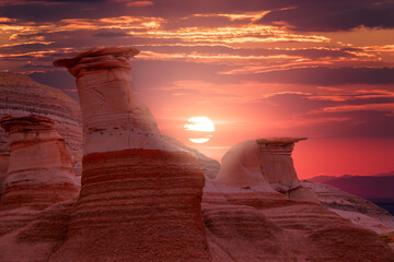 The sun sets over a couple of tall, thin spires of rock seen on the Hoodoo Trail (part of the...