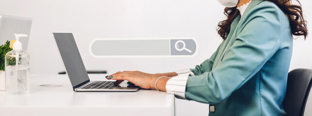 Young business woman using laptop computer working and typing on keyboard with search bar business...