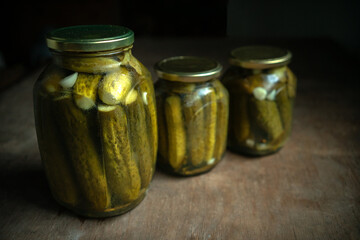 Pickles in round glass jars on a wooden table.Harvesting vegetables for the winter. Traditional Russian food