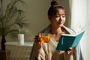 自宅でフルーツティーを飲みながらリラックスする若い女性