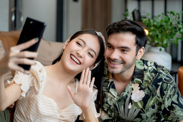 happiness asian and caucasian marry travel couple wearing casual cloth enjoy unpack suitcase luggage and selfie together on the floor with joyful laugh smile travel and vacation concept