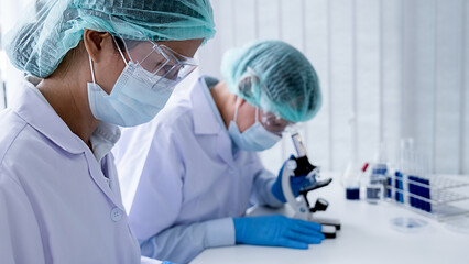 Medical or scientific researcher or man doctor looking at a test tube of clear solution in a laboratory