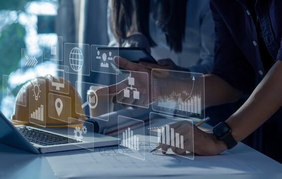 Construction and structure concept, engineer working with digital tablet computer and meeting for project working with partner on model building, technology network interface icons. 