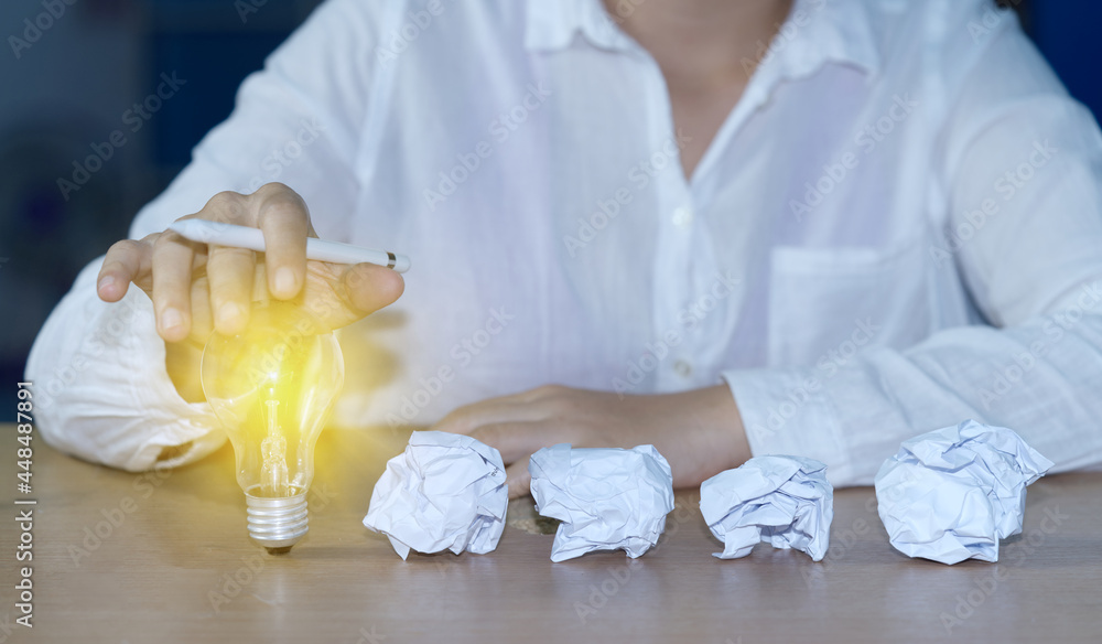 Aufkleber abstract businessman hand using stylus pen with light bulb and a pile of scrap paper. concept busine