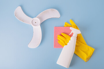 Cleaning supplies and a dusty dirty ventilation fan. isolated on blue background. top view