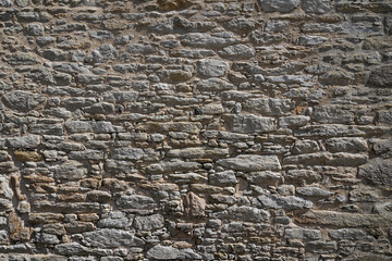 Old weathered stone dark wall of medieval brick horizontal grunge background