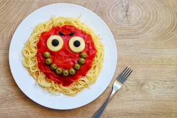 Cute smile monster spaghetti creative food for Halloween made from spaghetti,tomato sauce,black...