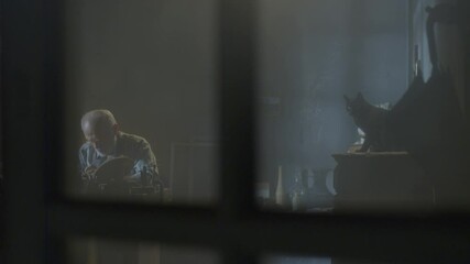 Footage of goldsmith working at table in workshop . Bearded old man jeweler creating new jewelry . Master goldsmith working process . Scenic film shot in vintage style. Shot on RED EPIC Camera.   