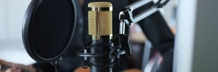 Gold modern professional studio microphone closeup background