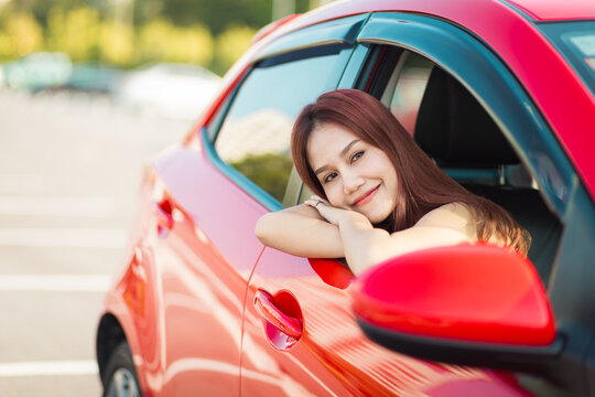 Beautiful asian woman enjoying life  in the red car.