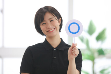 〇札を持つスポーツジムインストラクター