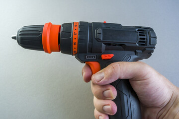 the man's hand holds a screwdriver. tool for machining holes and screwing. close-up drilling