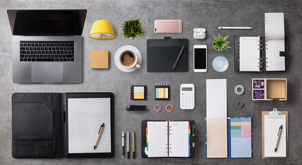 Flat lay top view office desk working space with laptop on gray background.