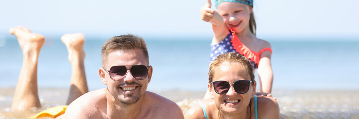 Family with little girl lying in sea