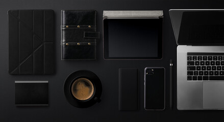 Flat lay top view office desk working space with laptop on black background.