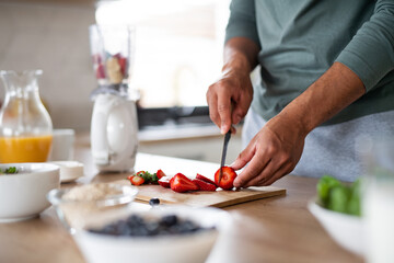Obraz na płótnie Canvas Unrecognizable man preparing smoothie indoors at home, healthy diet concept.