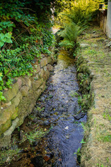 canalized small brook as flood protection measure in a village in southern germany