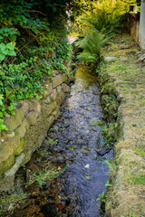 canalized small brook as flood protection measure in a village in southern germany