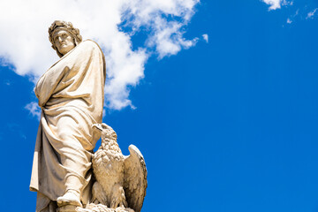 Dante Alighieri statue in Florence, Tuscany region, Italy, with amazing blue sky background.