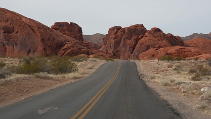 Road trip, driving auto in Valley of Fire, Las Vegas, Nevada, USA. Hitchhiking traveling in America, highway journey. Red alien rock formation, Mojave desert wilderness looks like Mars. View from car.