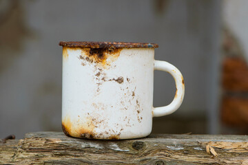 metal old dirty cup isolated. rusty iron cup, close-up. old tea utensils. a white mug stands on a...